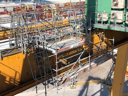 ANDAMIO TUBULAR EN DESCUELGUE SOBRE VIGA DE CARRIL DE GRÚA PÓRTICO